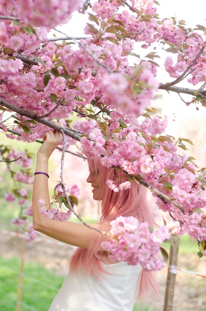 I fiori di Sakura circondano la ragazza. Sakura si diramò per il viso