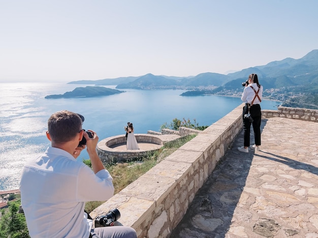 I fotografi scattano foto degli sposi sul ponte di osservazione sopra la baia di Kotor