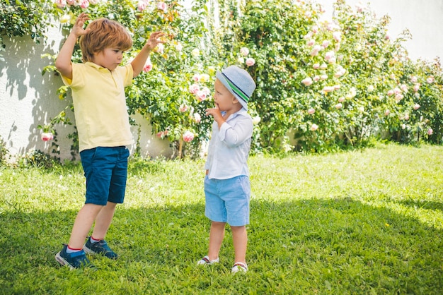 I fratelli camminano nel giardino di primavera i bambini all'aperto nel parco estivo i migliori amici