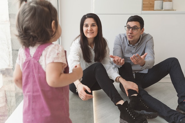 I genitori chiamano il loro bambino per sé. Papà tende la mano al bambino. Buona serata in famiglia