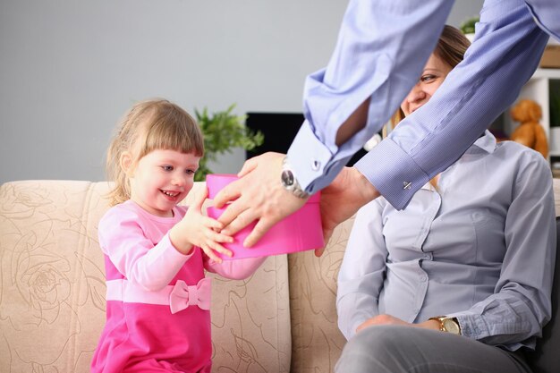 I genitori danno una confezione regalo per bambina