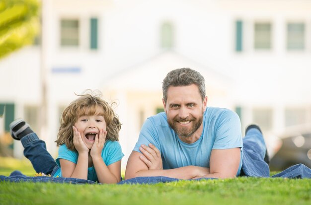 I genitori dell'infanzia e della genitorialità si rilassano con il bambino sull'erba papà con il bambino il giorno d'estate