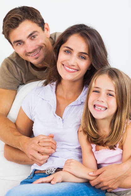 I genitori e la loro figlia sorridono