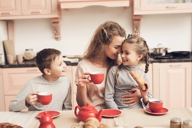 I genitori single mamma mamma hanno tè con croissant.