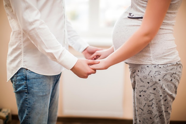 I genitori sono in gravidanza mentre aspettano che il bambino venga tenuto per mano