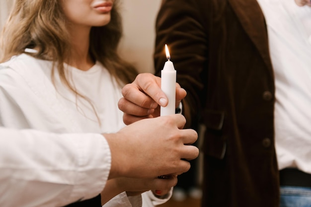 I genitori tengono una candela durante il rito del battesimo in chiesa