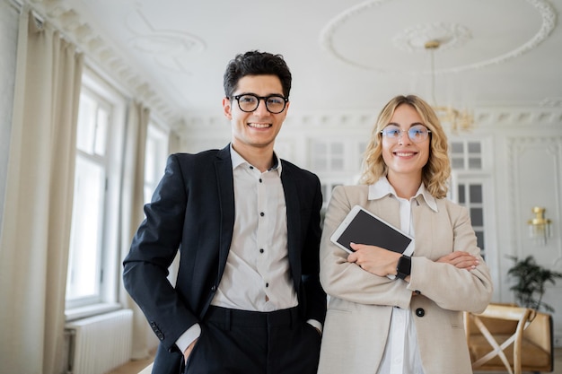 I gestori delle finanze un uomo e una donna lavorano insieme in un ufficio in abiti da lavoro