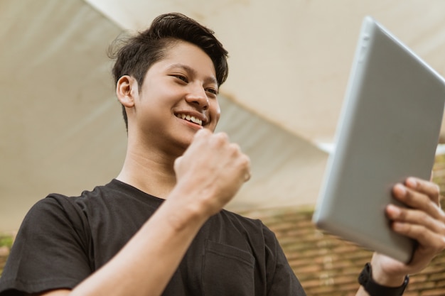 I giovani asiatici guardano lo schermo del tablet e poi ridono