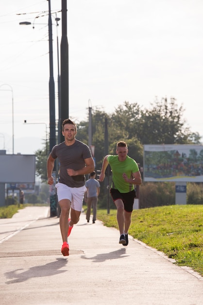 i giovani atletici si divertono a correre mentre il sole sorge sulla città