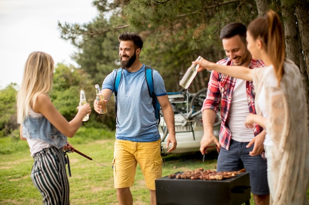 I giovani che godono barbecue party nella natura