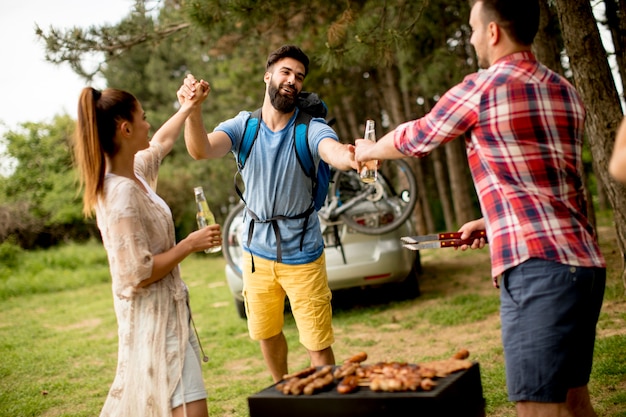 I giovani che godono barbecue party nella natura