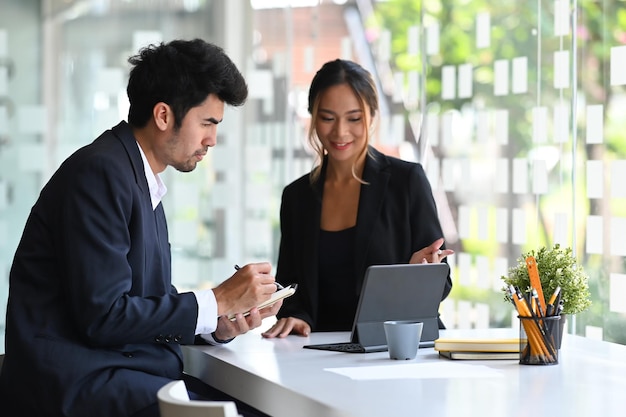 I giovani colleghi di lavoro che condividono idee prendono in considerazione la strategia per discutere la presentazione online sul posto di lavoro moderno