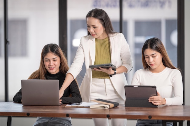 I giovani studenti universitari asiatici hanno un incontro con il tutor o il tutor dell'insegnante per discutere del progetto