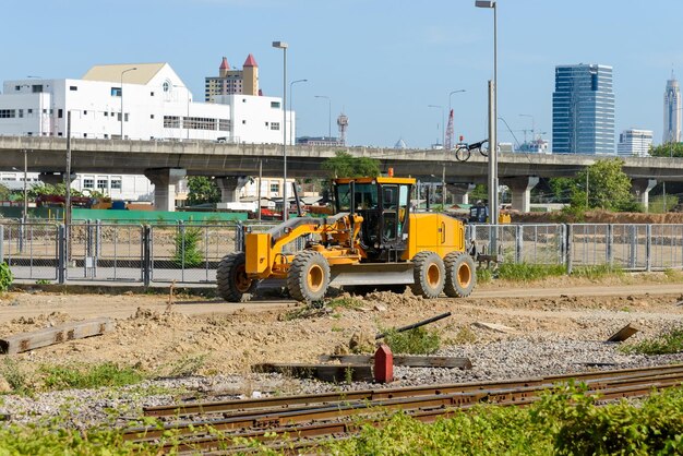 I grandi gradatori a motore parcheggiati vicino alla recinzione metallica del cantiere dopo le opere vista anteriore per lo spazio di copia