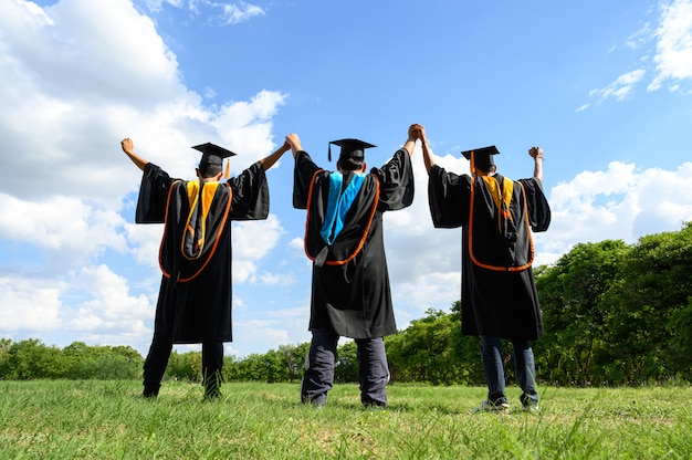 I laureati lanciano cappelli il giorno della laurea all&#39;università.