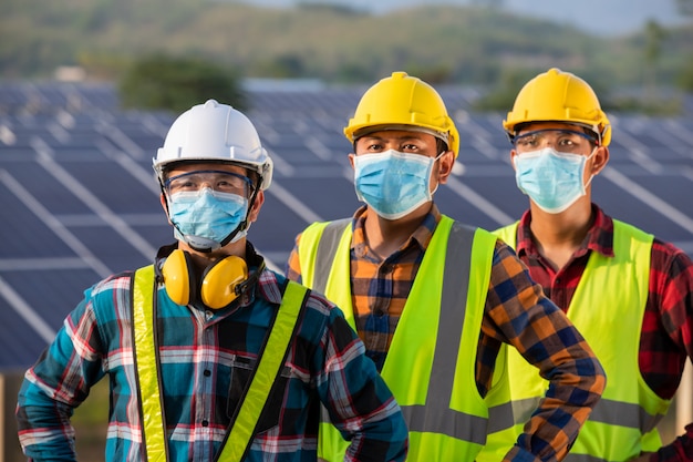 I lavoratori asiatici indossano maschere protettive per la sicurezza nel cantiere Elettricità Industria dell'energia solare, Energia naturale, Nuova normalità