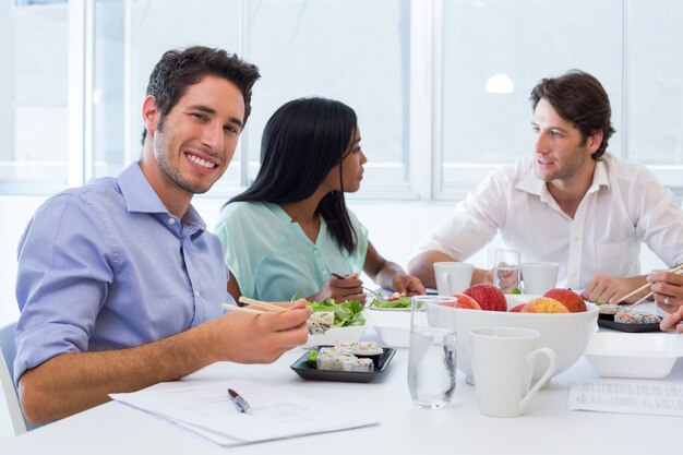 I lavoratori chiacchierano e sorridono alla telecamera mentre si godono il pranzo