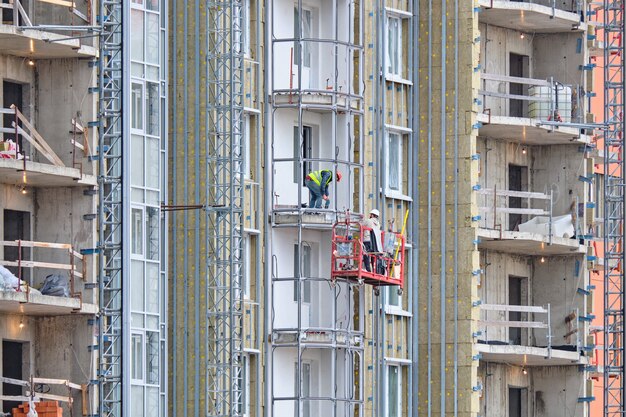 I lavoratori costruiscono un balcone in un nuovo edificio residenziale moderno