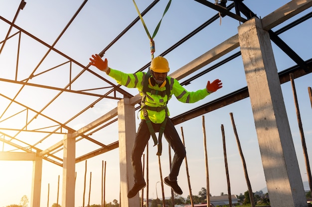 I lavoratori edili cadono da un'altezza ma hanno la sicurezza per aiutare. Concetto di prevenzione del pericolo dall'alto con sicurezza in cantiere.