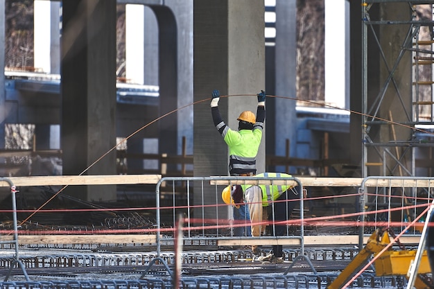 I lavoratori edili in cantiere lavorano con rinforzi in calcestruzzo