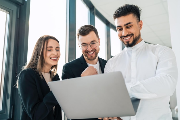 I lavoratori guardano nel laptop e ridono