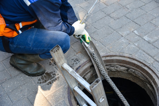 I lavoratori smantellano il cavo di telecomunicazione nel pozzo