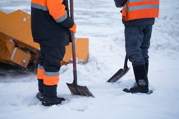 I lavoratori spazzano la neve dalla strada in inverno