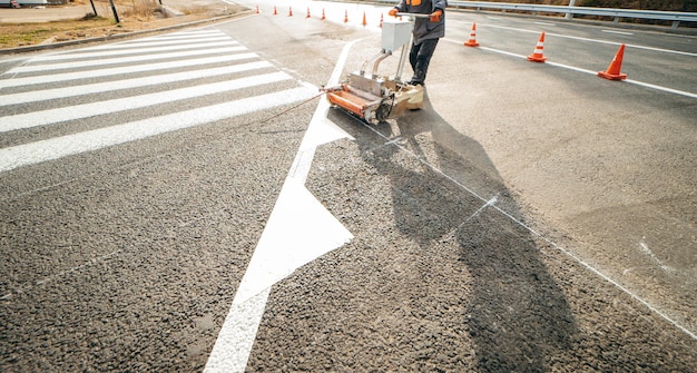 I lavoratori stradali usano macchine da disegno per dipingere le strisce pedonali sull'asfalto in città