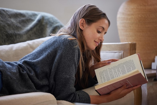 I libri non fanno mai perdere il senso dello stupore Inquadratura di una giovane donna che legge un libro a casa