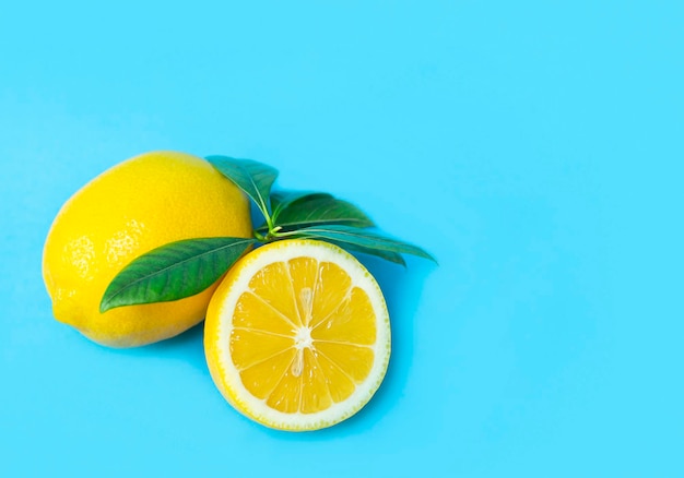 i limoni con le foglie giacciono su uno sfondo blu