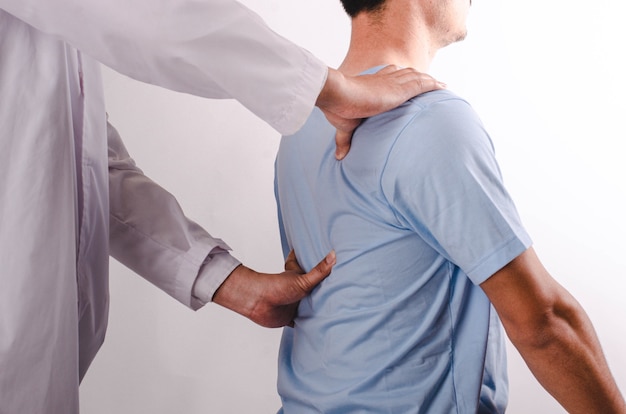 I medici eseguono la terapia fisica per i giovani uomini e forniscono consigli ai pazienti con problemi alla spalla.
