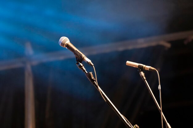 I microfoni preparati per il concerto nel palco buio mostrano uno sfondo blu scuro una scena scura e vuota