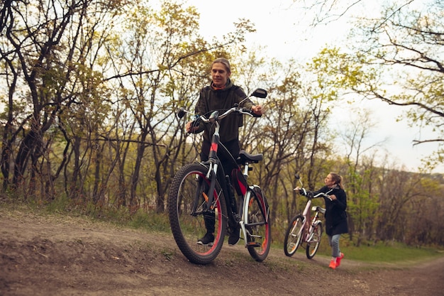 I migliori amici che si divertono vicino al parco di campagna, riposano dopo essere andati in bicicletta, trascorrono del tempo insieme