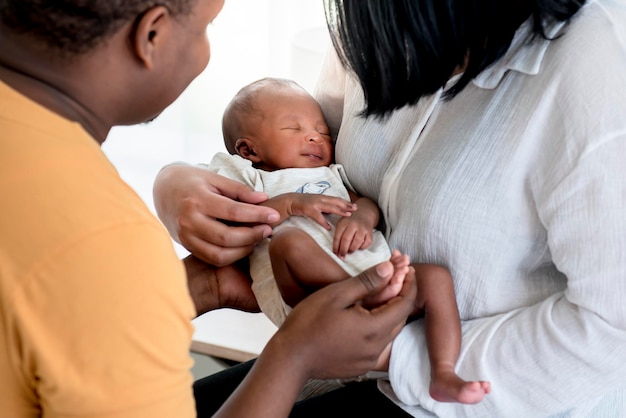 I neonati africani sono il sonno e il sorriso di felicità sulla mano di madre e padre che aiutano a trasportare