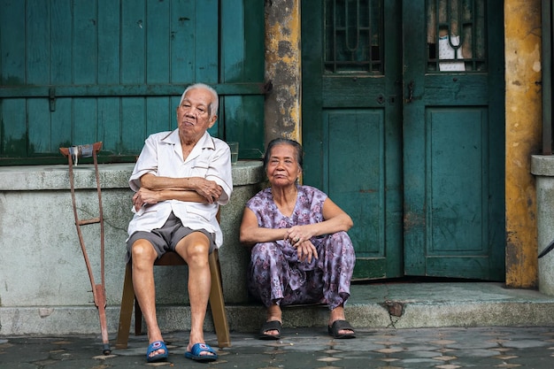 I nonni sono seduti vicino alla porta d'ingresso della loro casa. Hanoi. Vietnam.