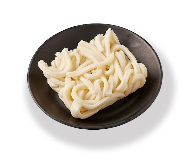 I noodle ramen congelati sono posti su un piatto nero isolato su sfondo bianco