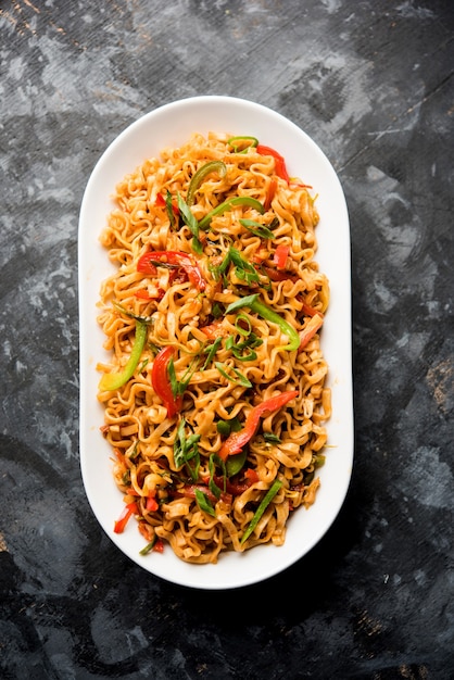 I noodles vegetariani di Schezwan sono noodles Hakka piccanti e gustosi saltati in padella con salsa e verdure. servito con le bacchette. messa a fuoco selettiva