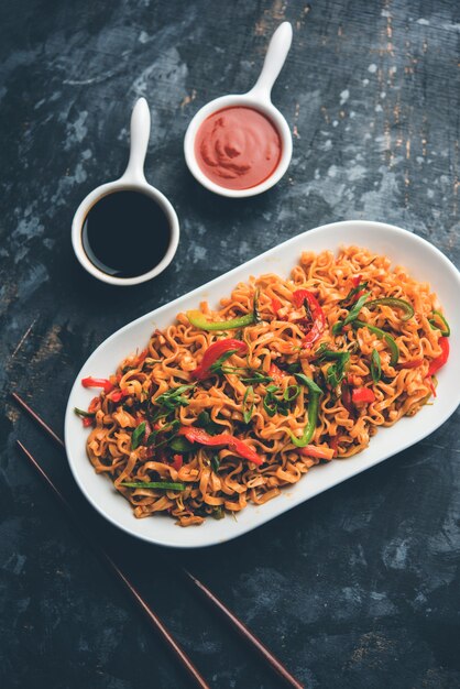 I noodles vegetariani di Schezwan sono noodles Hakka piccanti e gustosi saltati in padella con salsa e verdure. servito con le bacchette. messa a fuoco selettiva