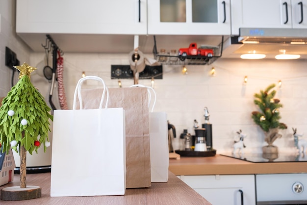 I pacchi del servizio di consegna sono sul tavolo della cucina addobbato per i regali di Natale e i piatti pronti vengono consegnati e preparati per il nuovo anno