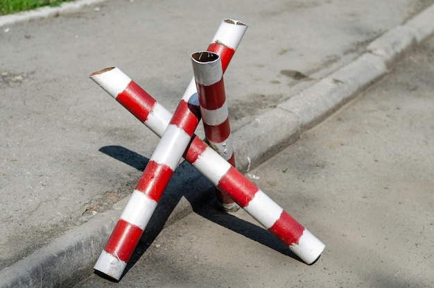 I pali a strisce rosse e bianche sono posizionati sulla strada.