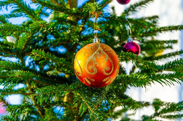 I palloncini giocattolo sono appesi all'albero di Natale sulla strada.