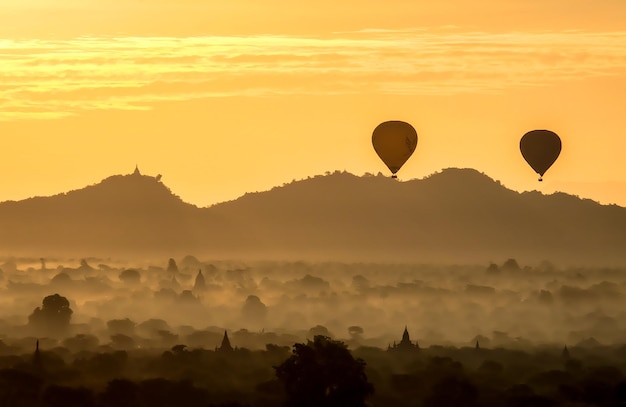 I palloncini hanno sorvolato la pagoda nella nebbia mattutina a Bagan