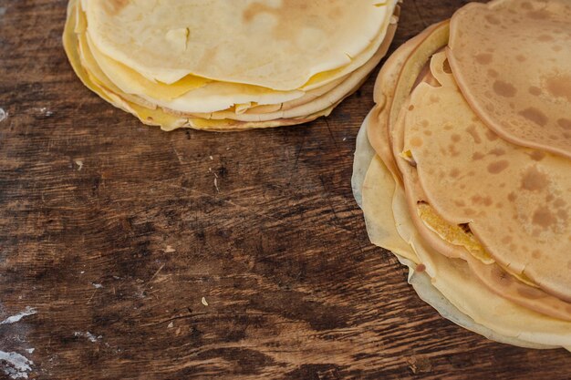 I pancake si chiudono. Frittelle su fondo di legno. Una pila di frittelle su un supporto di legno.