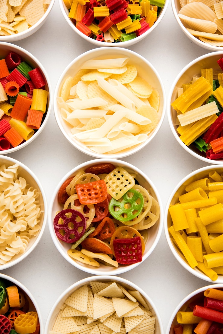 Foto i pellet snack sono prodotti non espansi realizzati con materie prime come cereali, patate o polveri vegetali, successivamente lavorati mediante frittura, cottura ad aria calda. snack pronti multicolori o sagomati