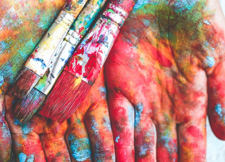 Foto i pennelli sono su mani colorate dipinte