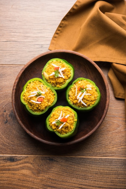 I peperoni ripieni o bharwa shimla mirchi sono una ricetta popolare indiana per il piatto principale. Servito in un piatto su sfondo lunatico. Messa a fuoco selettiva