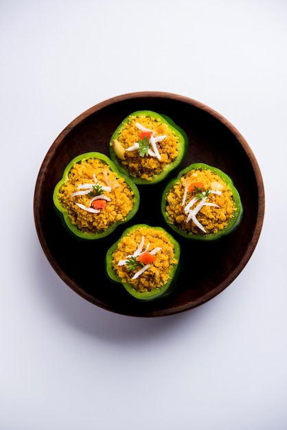 I peperoni ripieni o bharwa shimla mirchi sono una ricetta popolare indiana per il piatto principale. Servito in un piatto su sfondo lunatico. Messa a fuoco selettiva
