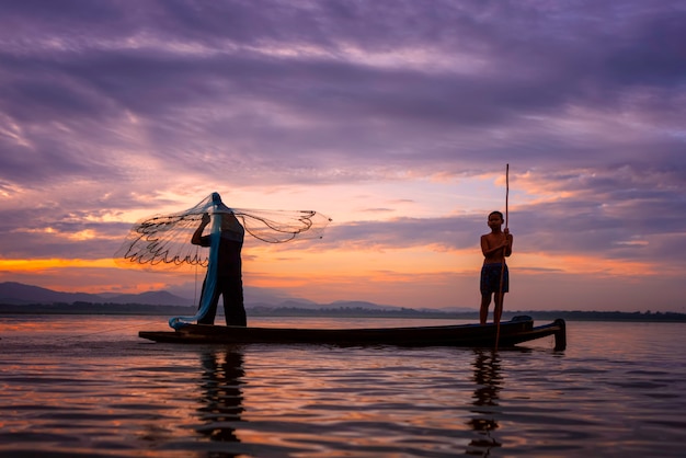 I pescatori Casting stanno andando a pescare la mattina presto con barche di legno, vecchie lanterne e reti. Concetto Stile di vita del pescatore