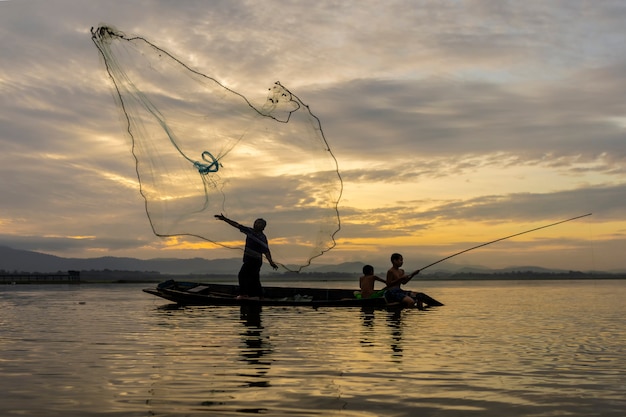 I pescatori Casting stanno andando a pescare la mattina presto con barche di legno, vecchie lanterne e reti. Concetto Stile di vita del pescatore.