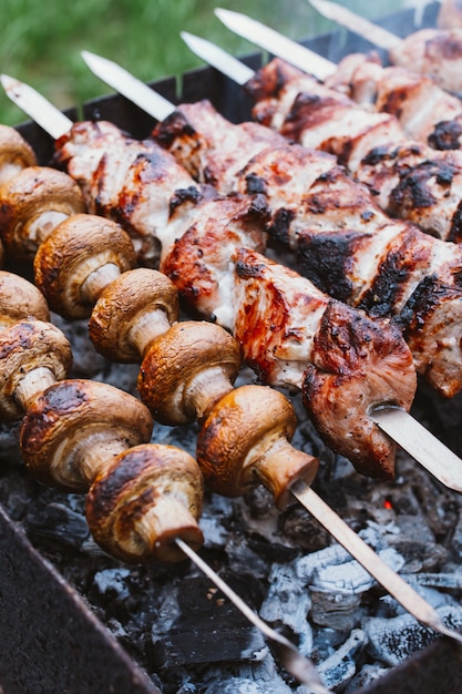 I pezzi di carne e funghi marinati sono grigliati su carbone